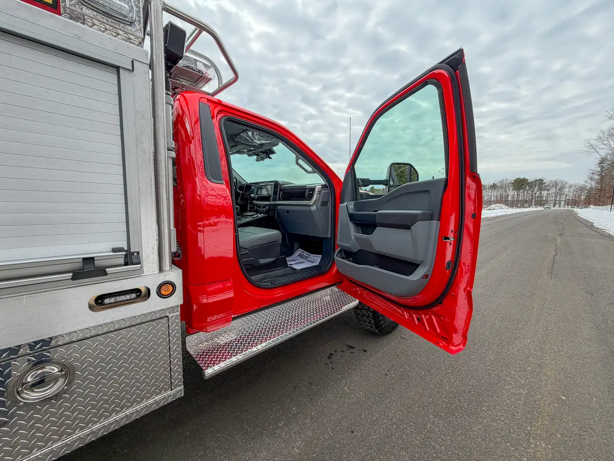 Open driver door from rear angle showing cabin entry and controls.